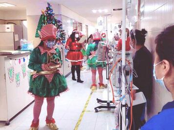 Elfos y ayudantes de Santa visitan a niños con cáncer