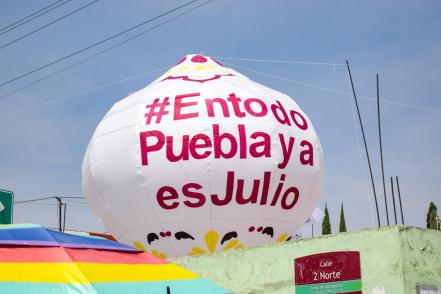 ¡Políticos hacen su agosto! Se promocionan con gorras y sombrillas en el desfile del 5 de mayo