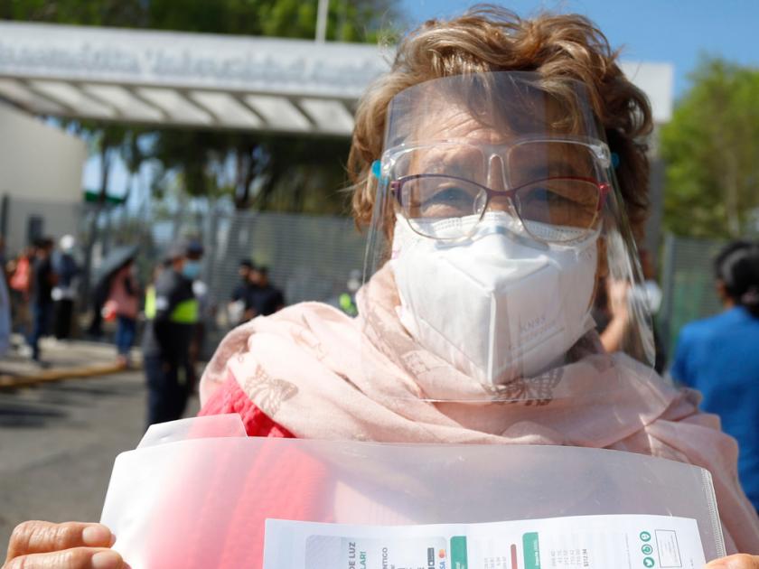 Adultos salen contentos por haber sido inmunizados contra el coronavirus en Puebla.